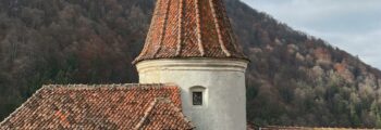 Grande bâtisse avec dôme, voitures vintage, ciel bleu.