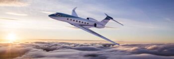 G550 jet privé en vol au dessus des nuages au couché de soleil